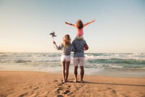 family facing ocean standing in stand